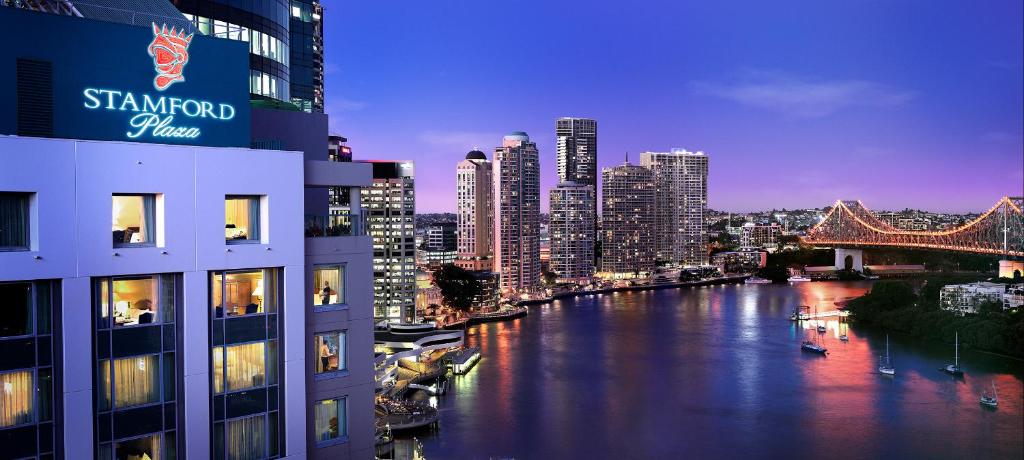 a view of a river with buildings and a bridge at Stamford Plaza Brisbane in Brisbane