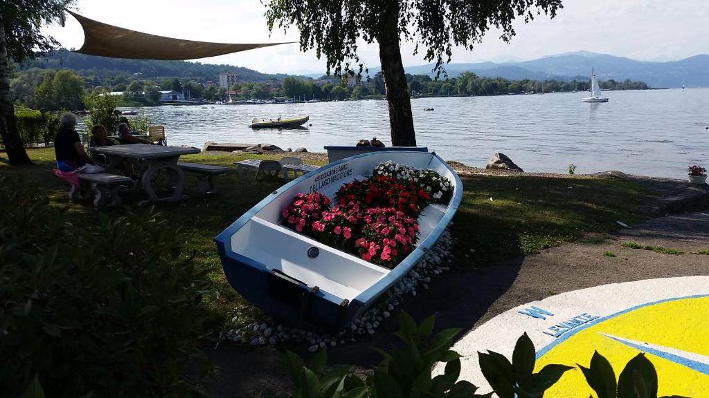 a boat full of flowers on the shore of a lake at Appartamento Lago Maggiore in Castelletto sopra Ticino