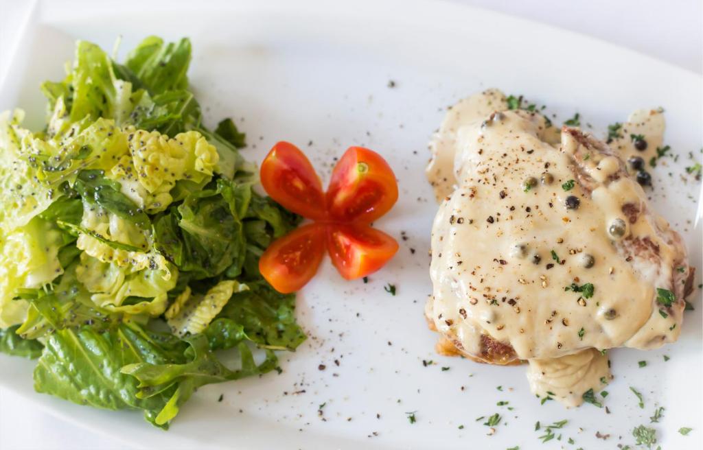 a plate of food with a salad and vegetables at Thirides Beach Resort in Gythio