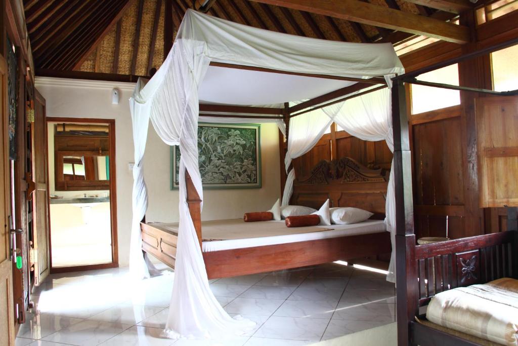 een slaapkamer met een hemelbed in een kamer bij Puri Brata in Parangtritis