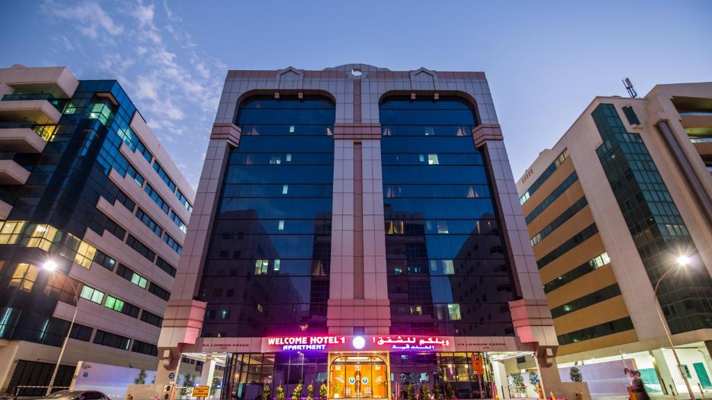 a tall building with a sign in front of it at Welcome Hotel Apartments 1 in Dubai