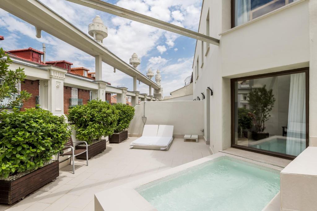 a patio area with a pool and a balcony at Room Mate Alicia in Madrid