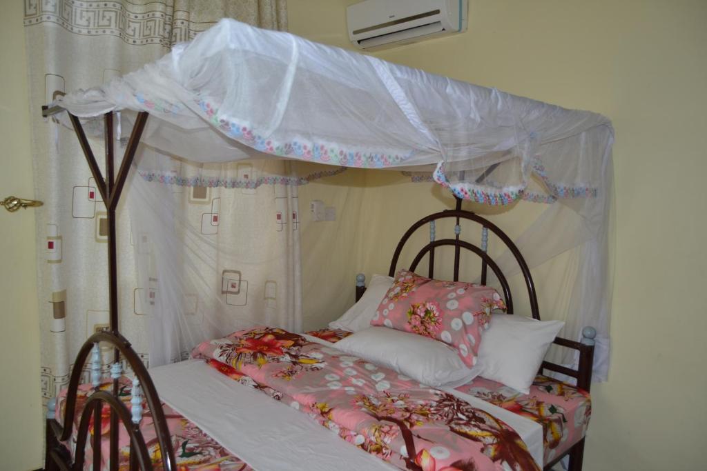 a bedroom with a bed with a canopy at Barcelona Lodge in Bagamoyo