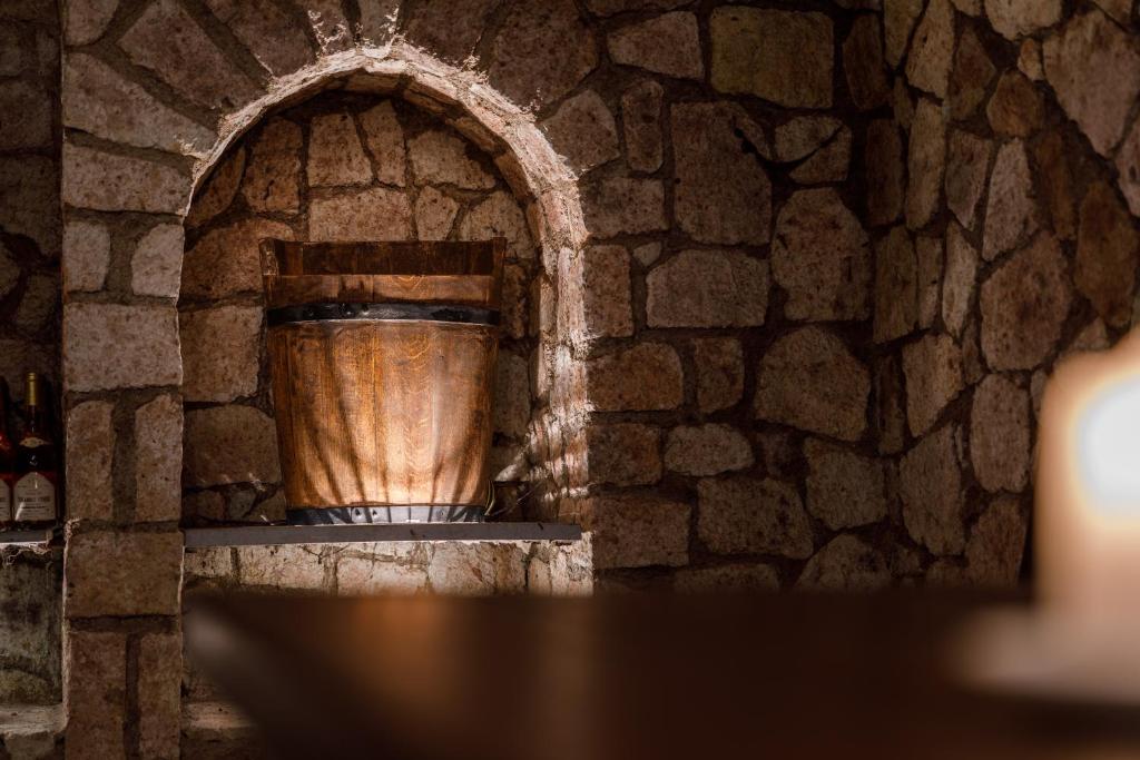 um grande vaso de madeira numa prateleira numa parede de pedra em Penzión Zlatá Putňa em Viničky