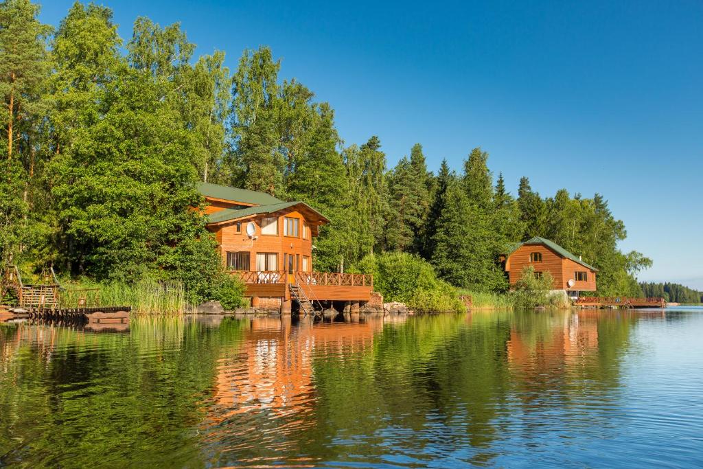 ein Haus am Ufer eines Wasserkörpers in der Unterkunft Holiday Park Lesnaya Skazka in Wyborg