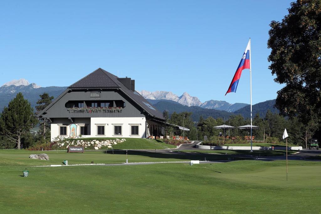 um campo de golfe com bandeira e um edifício em King's and Lake's House Golf Course Royal Bled em Bled