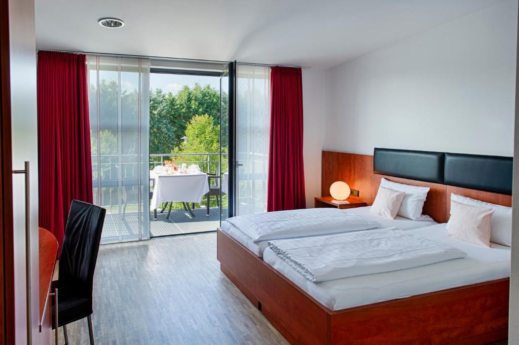 a bedroom with a bed and a balcony with a table at CFK - Spiesen-Elversberg in Spiesen-Elversberg