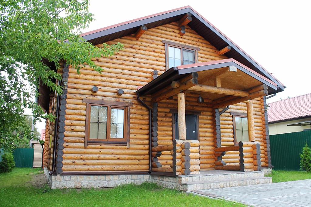 a log cabin with windows on the side of it at Guest House Lyubyatovo in Pskov