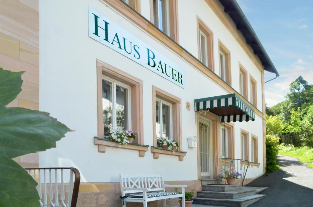 un bâtiment avec un panneau indiquant les heures d'agriculteur dans l'établissement Hotel Haus Bauer, à Bad Berneck im Fichtelgebirge