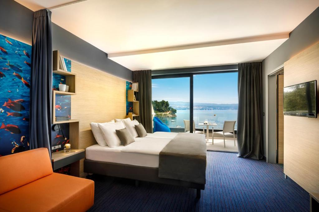 Cette chambre comprend un lit et une grande fenêtre. dans l'établissement Hotel Ičići - Liburnia, à Opatija