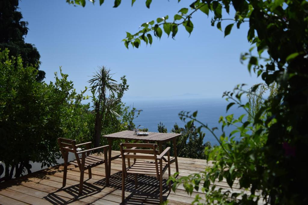 a table and chairs on a deck with the ocean in the background at Casa Flora B&B in Vietri