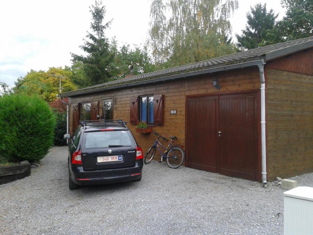 a car parked in front of a building with a bike at chalet Imme in Resteigne