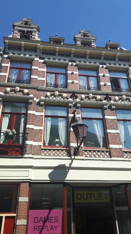 un edificio de ladrillo alto con muchas ventanas. en verzorgde kamer in monumentenpand en Arnhem
