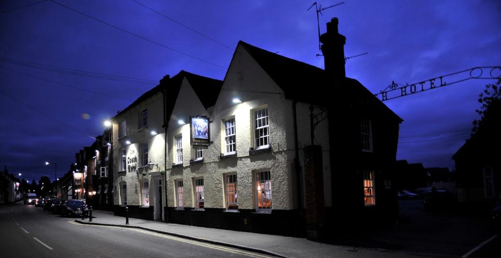 a lit up building on a street at night at The Coach Hotel in Coleshill