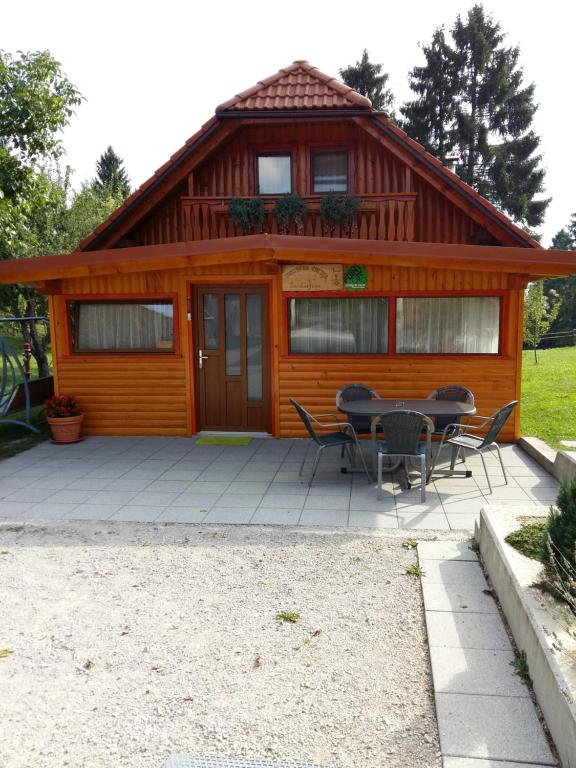een hut met een tafel en stoelen ervoor bij Tourist Farm Znidarjevi in Kožljek
