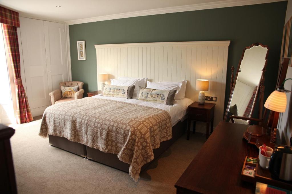 a bedroom with a large bed and a mirror at The Erskine Arms in Conwy