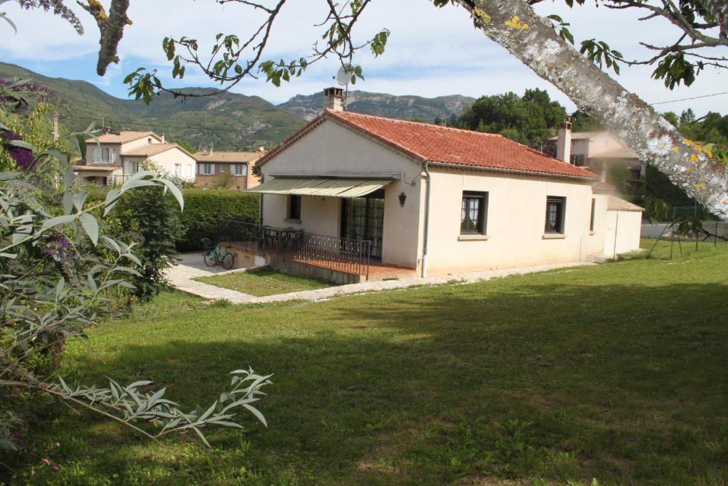 a small white house with a grass yard at Castellane Maison Cebiere in Castellane
