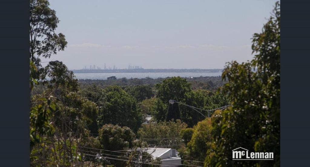 a view of a city from a hill with trees at 6 Bedrooms/9 Beds Huge House|City+Park Views|Beach in Frankston