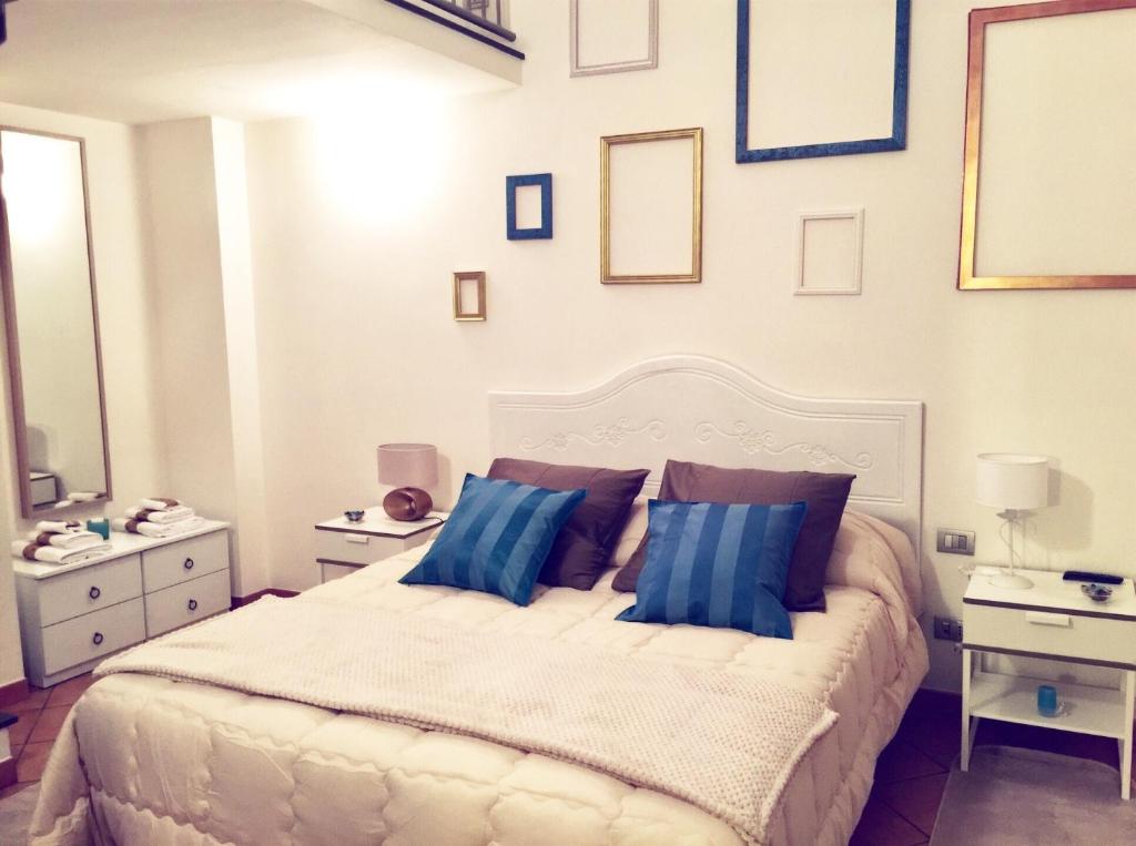 a bedroom with a large white bed with blue pillows at Gallery Bellini Apartment in Naples