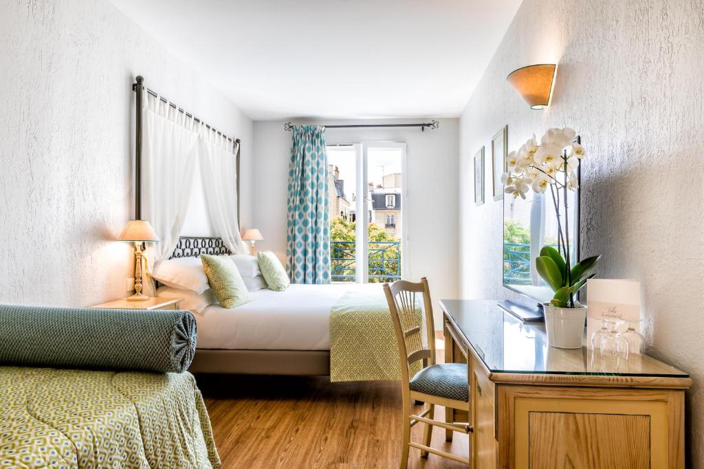 a bedroom with a bed and a desk and a table with a desk at Villa Alessandra in Paris