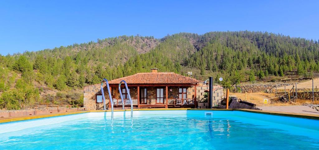 a house with a swimming pool in front of a house at Casa Rural Altos Cruz de Tea in Granadilla de Abona