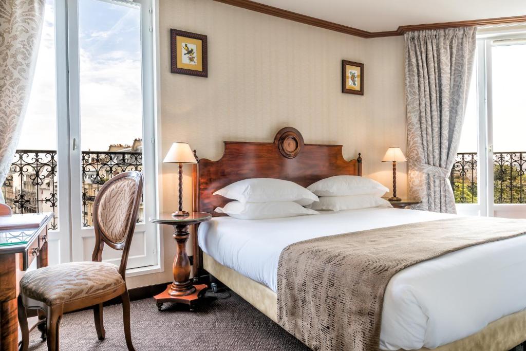 パリにあるヴィラ モンパルナスのベッドとバルコニー付きのホテルルーム