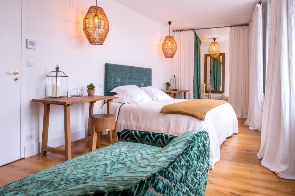 a bedroom with two beds and a table and a couch at La Palmeraie in La Baule