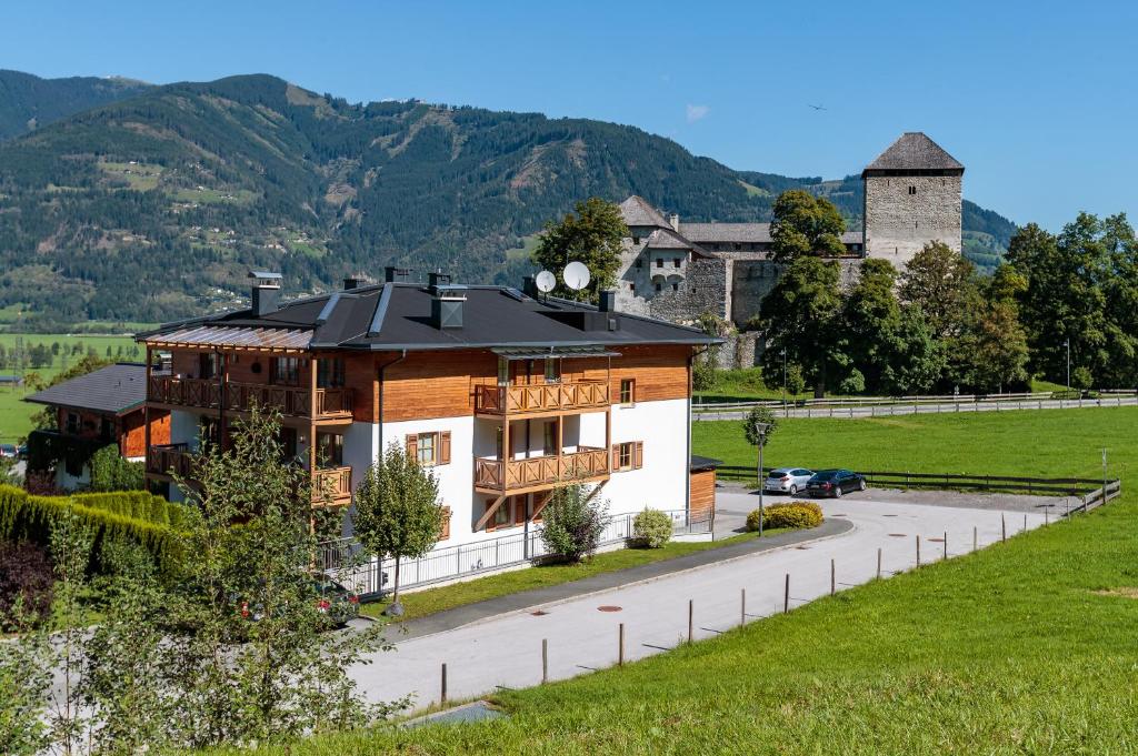 a house with a black roof on a road at AvenidA Residenz an der Burg by Alpin Rentals in Kaprun