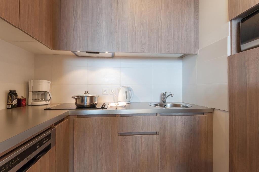 a kitchen with wooden cabinets and a sink at Résidence Pierre & Vacances Atria-Crozats in Avoriaz
