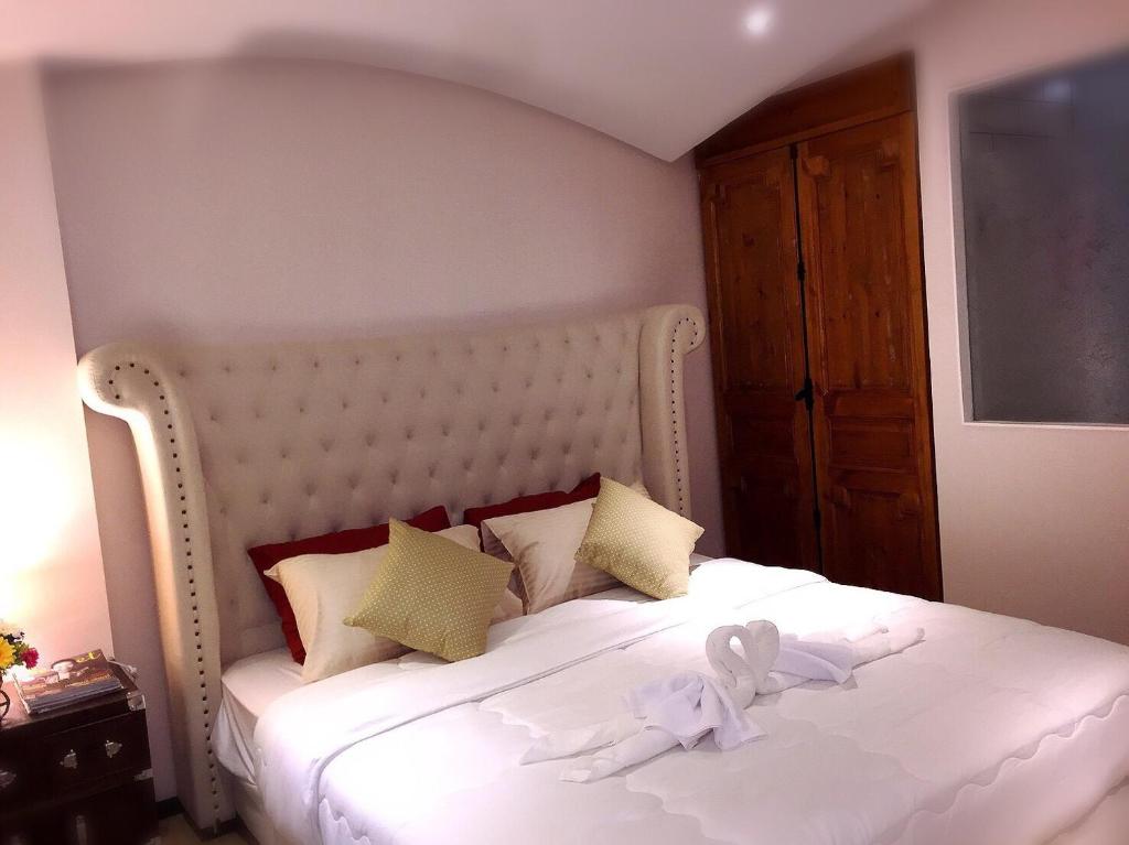 een slaapkamer met een wit bed met een knuffeldier erop bij Venetian Signature PoolAccess Resort Jomtian Pattaya in Jomtien Beach
