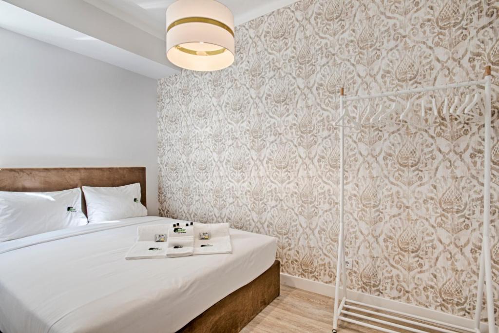 リスボンにあるBmyGuest - Ambassador Boutique Apartment IIの白いベッドと壁が備わるベッドルーム1室が備わります。