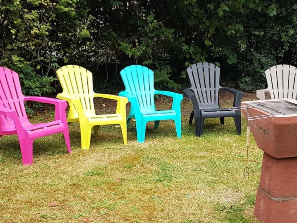 een groep kleurrijke stoelen in het gras bij Gite cosy proche Fontainebleau et foret in Noisy-sur-École