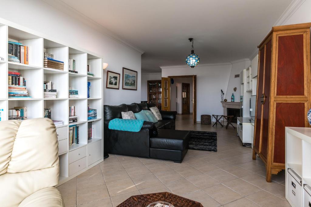 a living room with a couch and book shelves at Casa das Conchas in Ericeira