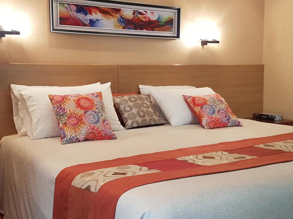 a hotel room with a bed with pillows at Spurwing Guest House in Nairobi
