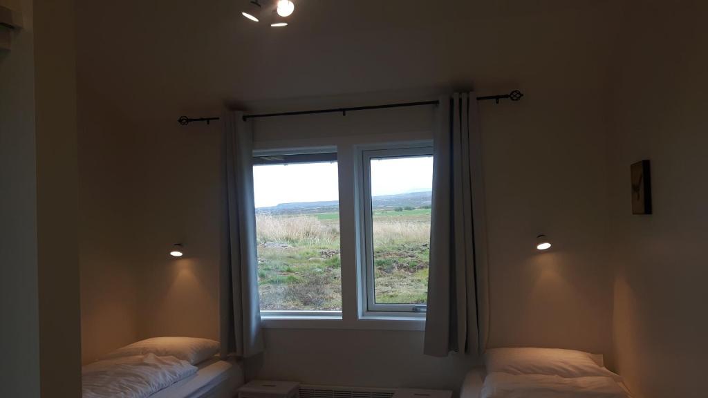 Rúm í herbergi á Hjartarstaðir Guesthouse