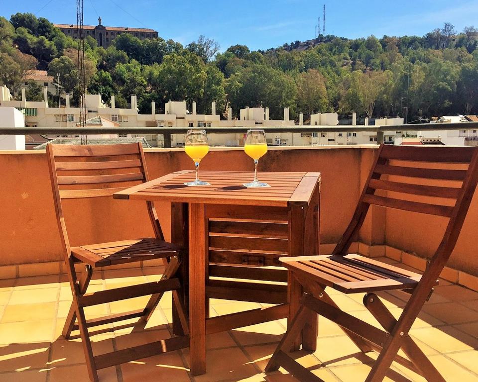two glasses of wine sitting on a table on a balcony at Zenit Málaga in Málaga