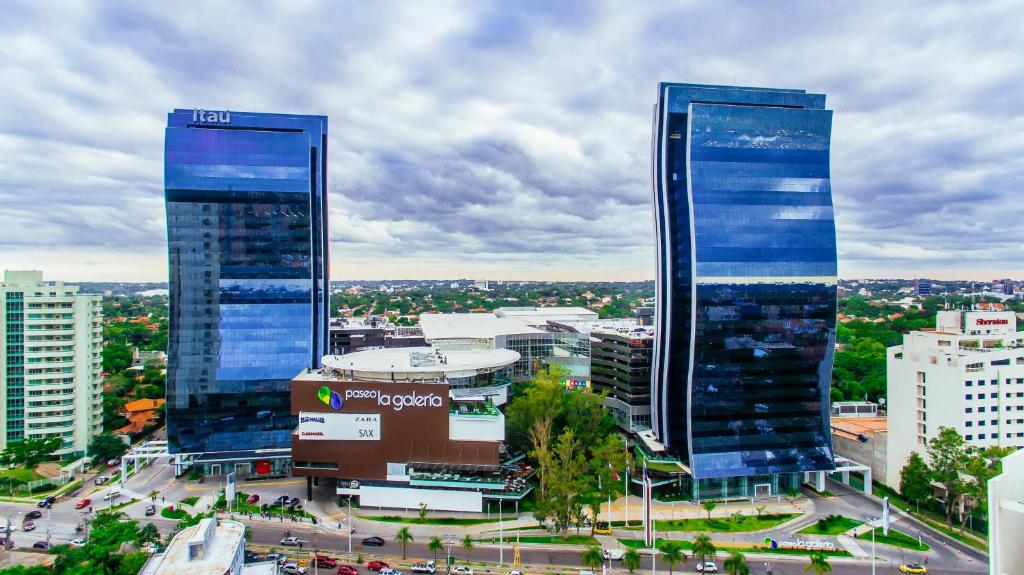 een stad met twee hoge wolkenkrabbers in een stad bij Paseo La Galería Hotel & Suites in Asuncion