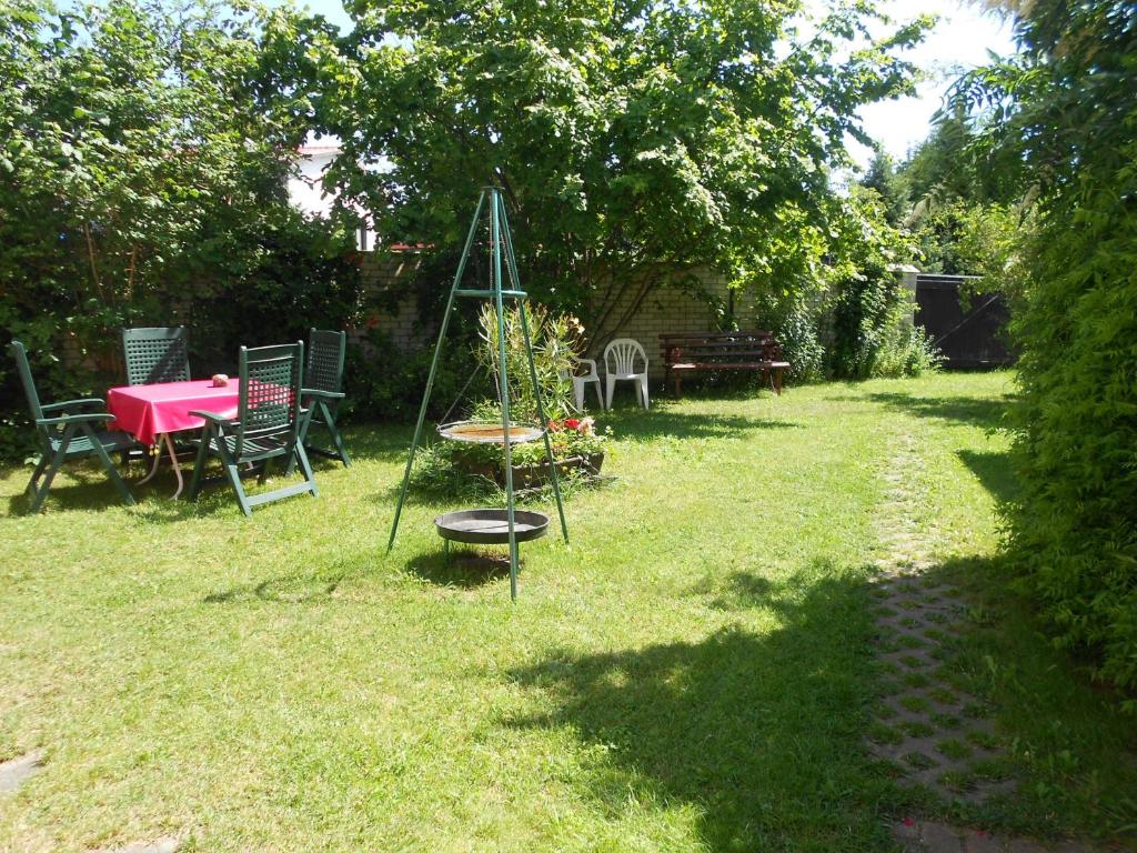 einen Garten mit einem Tisch und einem Baum im Gras in der Unterkunft Ferienwohnungen Ute Simdorn in Görke