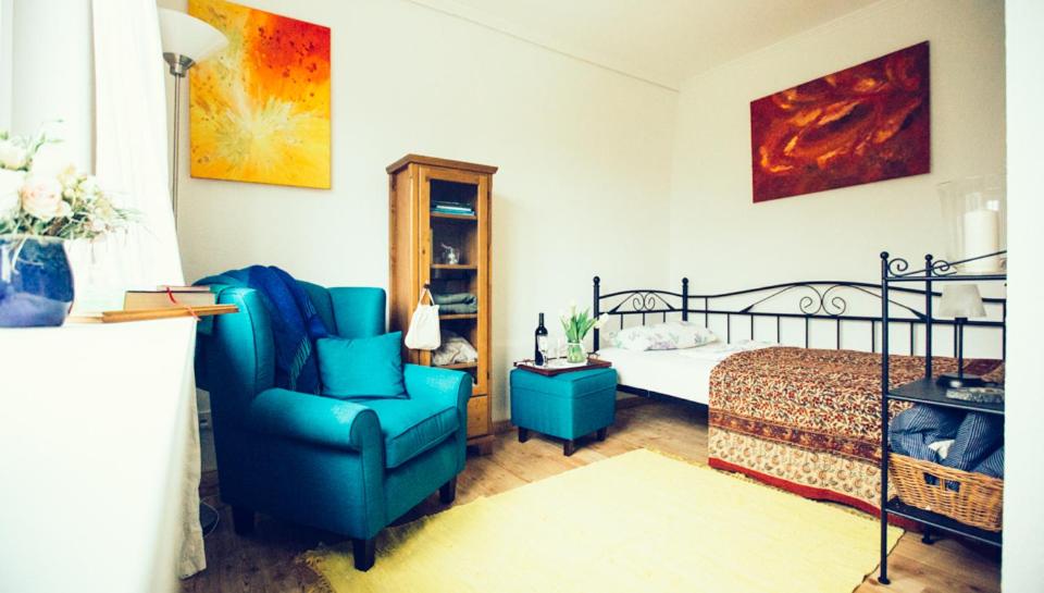 Un dormitorio con una silla azul y una cama en Das Blaue Haus en Husum