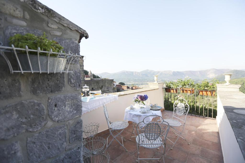 a patio with a table and chairs on a wall at Casa Aulivo in Caiazzo