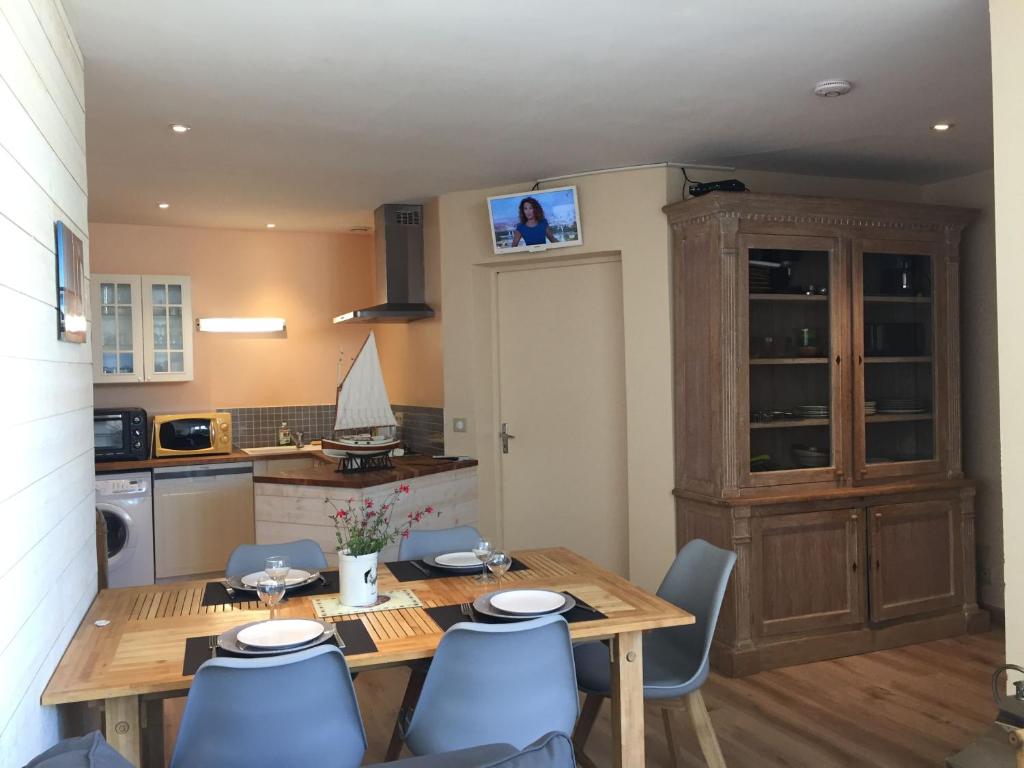 une cuisine avec une table en bois et des chaises bleues dans l'établissement clos de la poudriere, à Saint-Martin-de-Ré