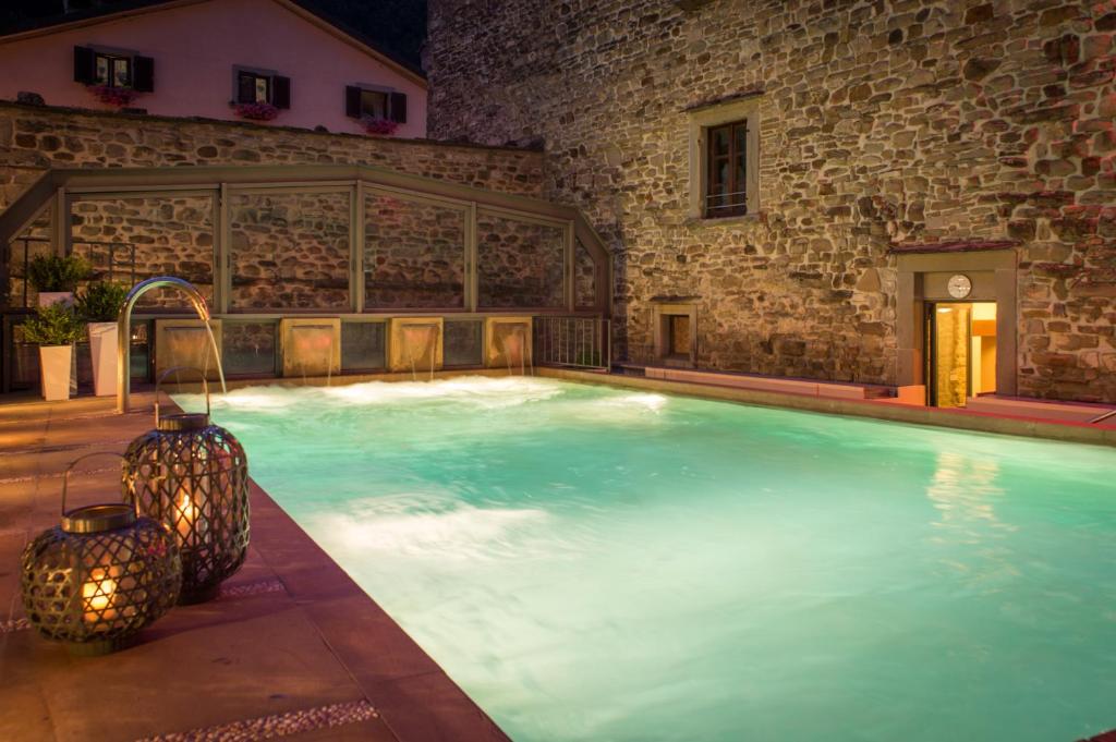 een groot zwembad in een gebouw met een stenen muur bij Hotel Delle Terme Santa Agnese in Bagno di Romagna