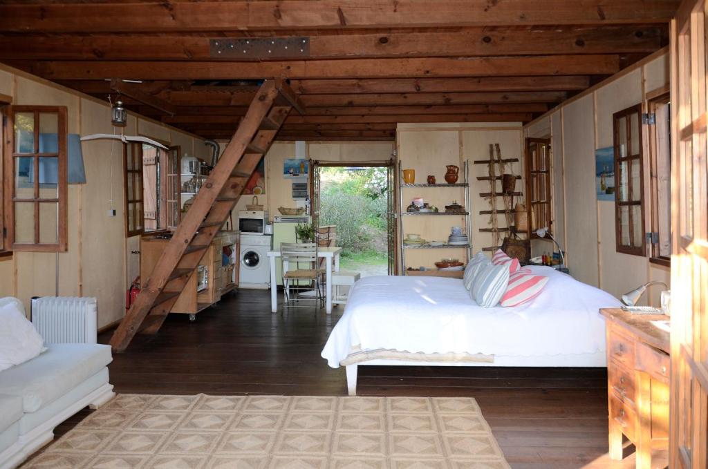 a bedroom with a white bed and a kitchen at Ha Mar ao Luar in Setúbal