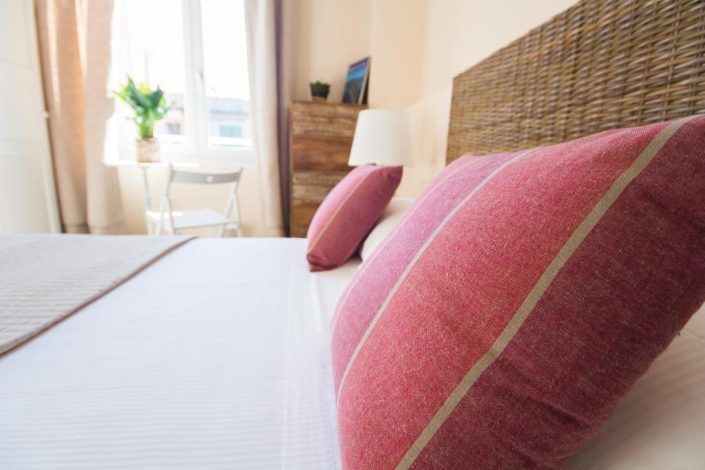 a bedroom with a bed with two pillows and a window at Emily Rooms in Sanremo