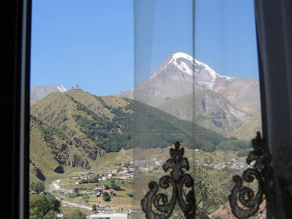 a view of a mountain from a window at Nino Khetaguri Guest House in Stepantsminda