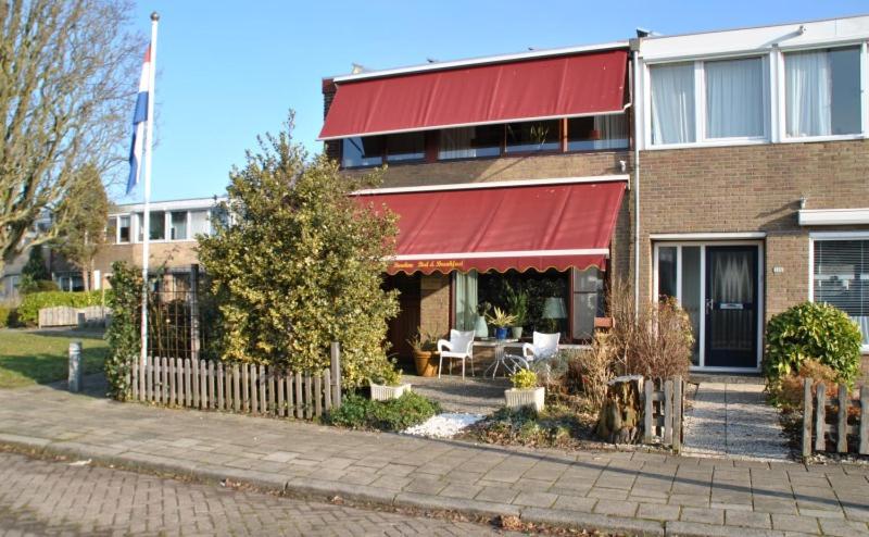 een bakstenen gebouw met een rode luifel erop bij Bordine Guesthouse in Leeuwarden
