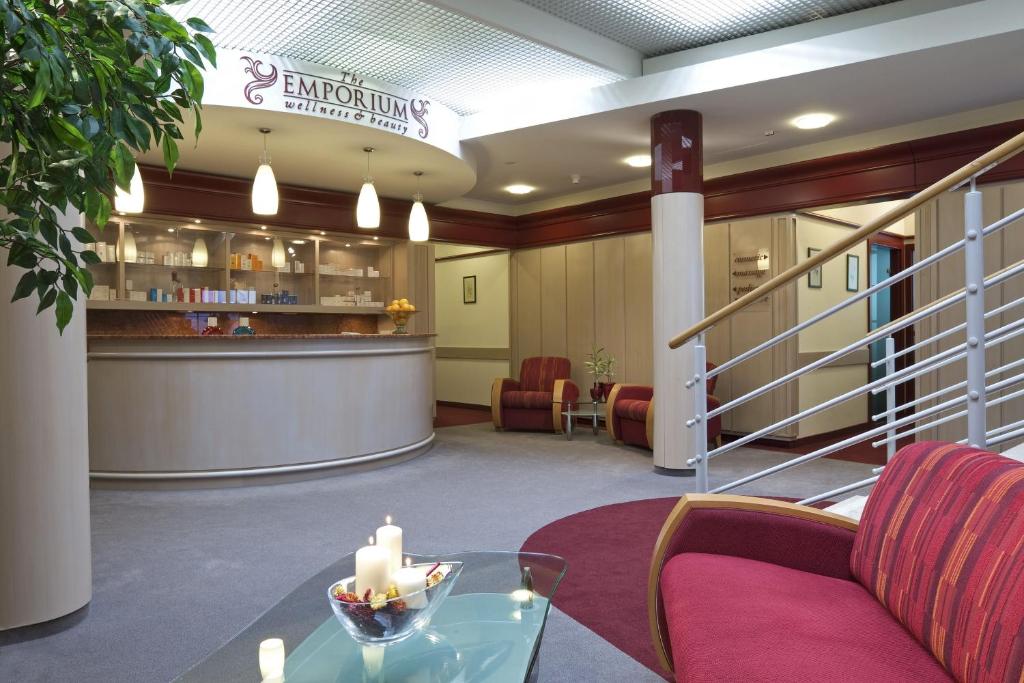 a waiting room with a table and a bar at Ensana Thermal Hévíz in Hévíz