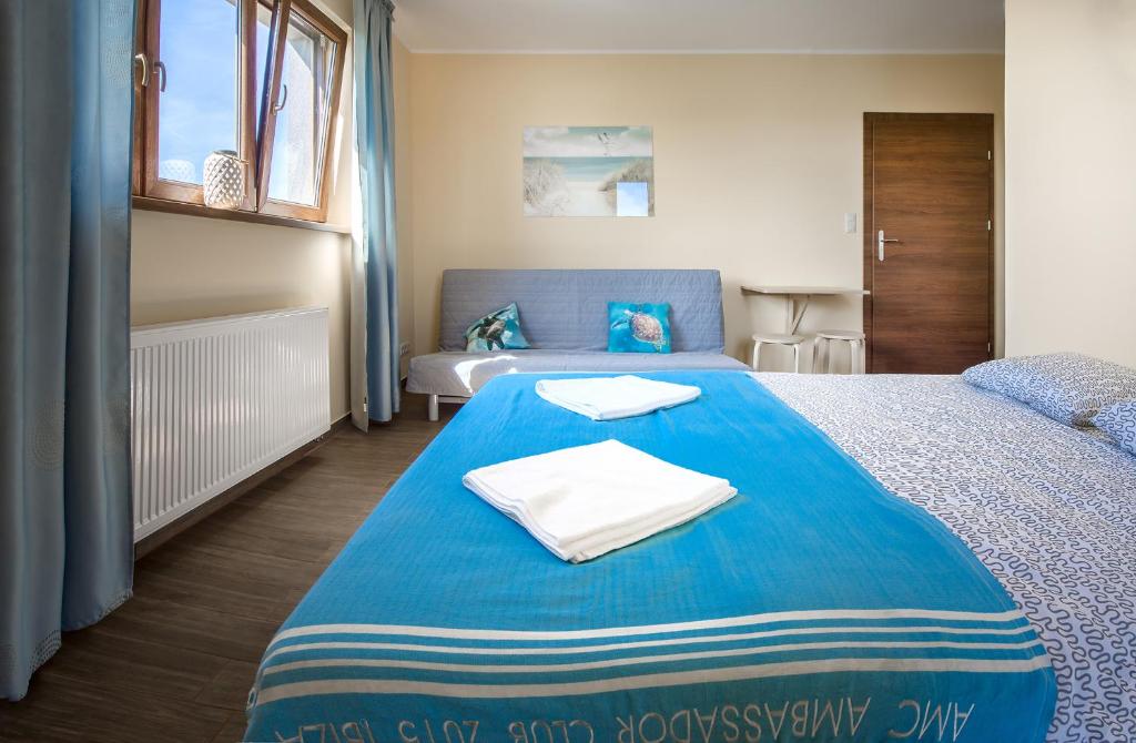 a bedroom with two beds and a blue blanket at Villa Rodzinna in Ustronie Morskie