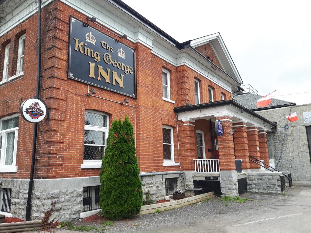 um edifício de tijolos com um sinal que lê o comboio do motor rei em The King George Inn em Cobourg