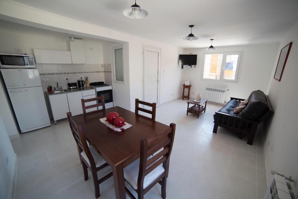 cocina y sala de estar con mesa y sillas en Aparthotel Aldea Termal en Copahue